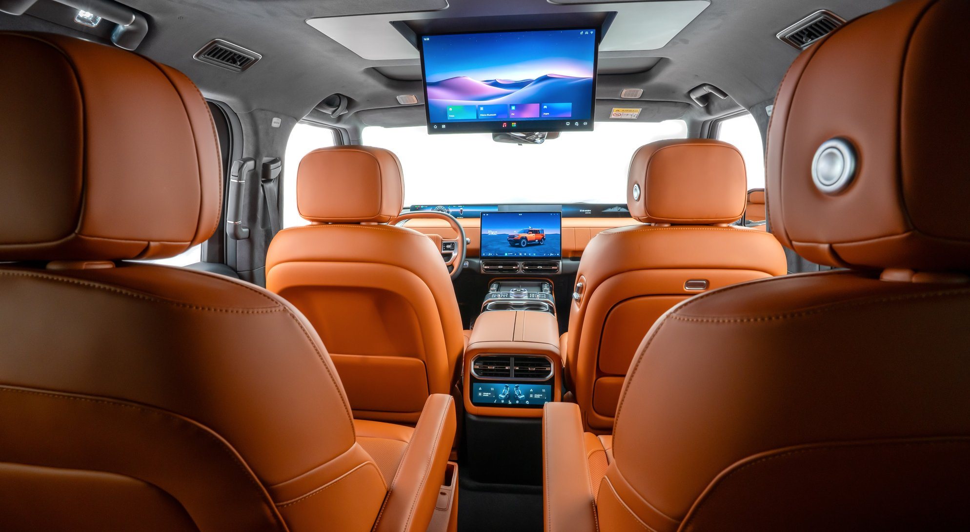 Cabine do JETOUR G700 vista da 3ª fileira, com poltronas terracota e tela de entretenimento no teto